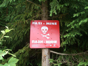 Advisory sign indicating active landmines in the forest